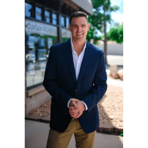 A real estate agent with clasped hands pose