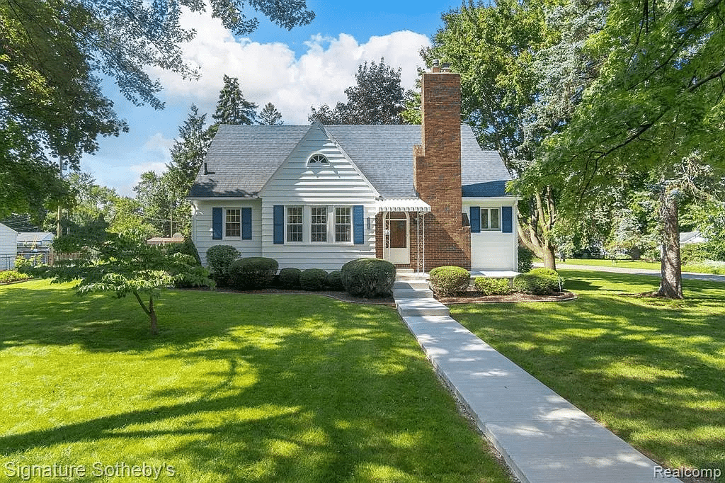 A white craftsman house with a lush lawn