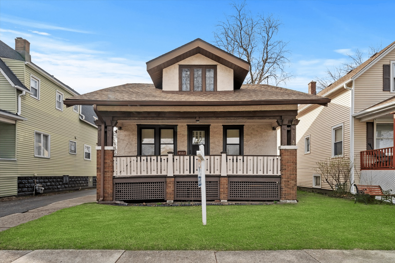 A brown, frame stucco bungalow house